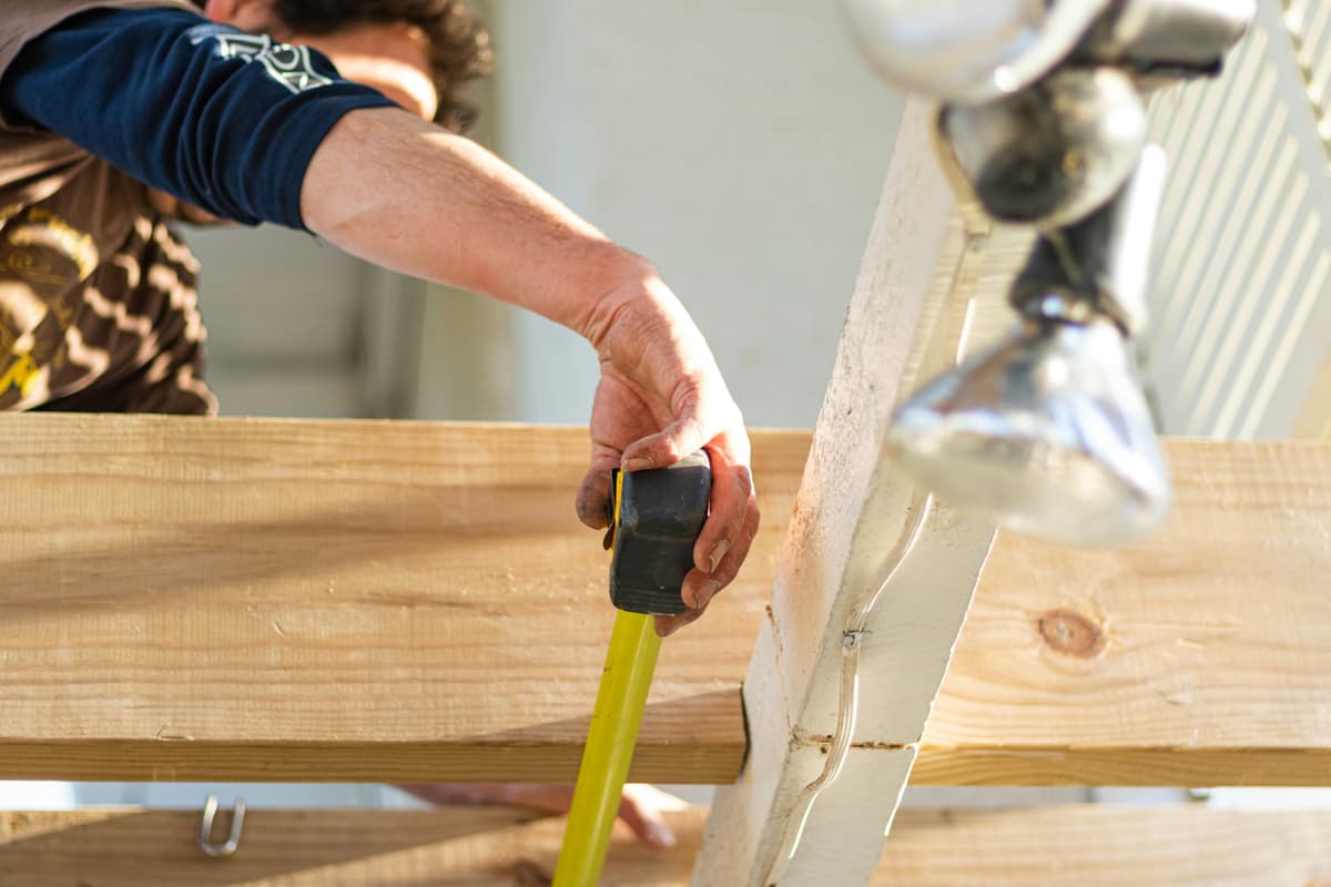 Tape measure checking a length of framing timber