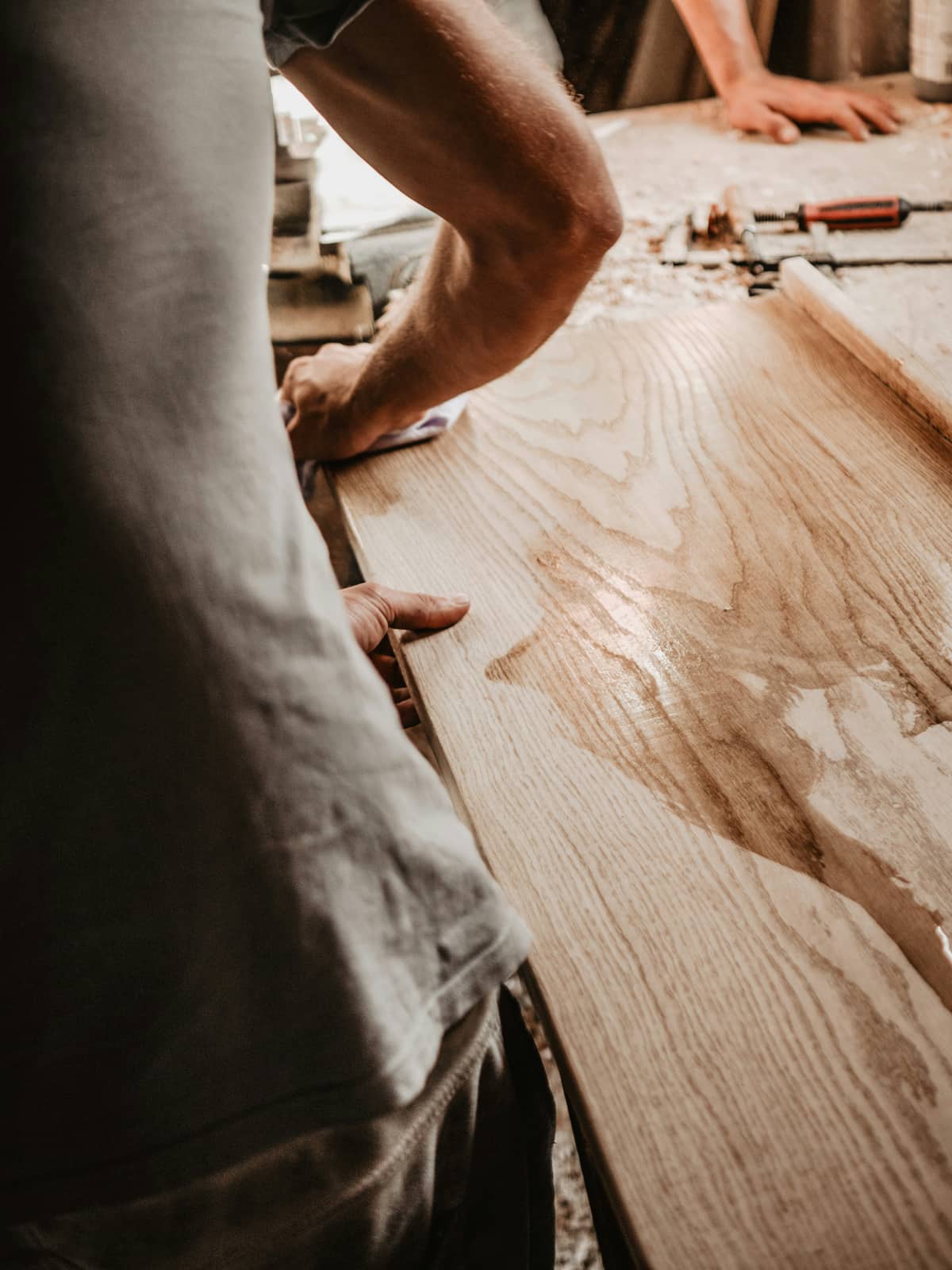Carpenter planing a timber slab in the workshop