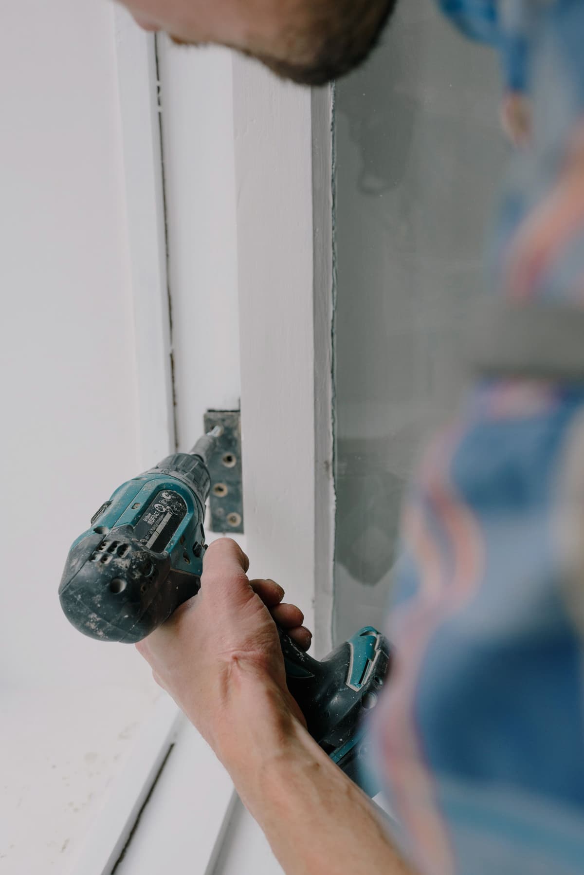 Drill fixing a hinge to a door frame
